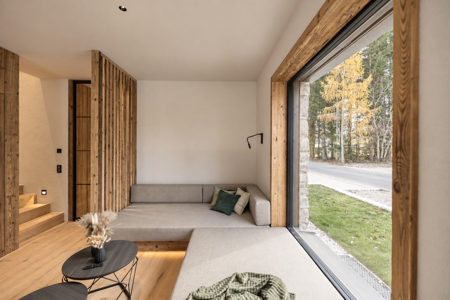 Fenstersitzplatz mit grauen Polstern und Blick ins Grüne