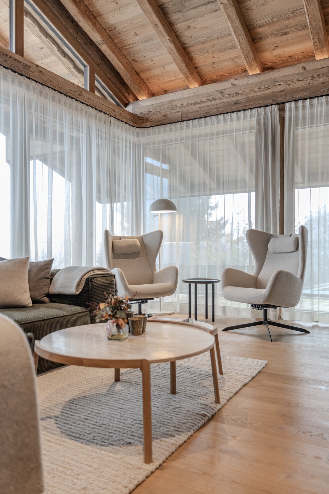 Sitzgruppe mit rundem Couchtisch, Polstermöbeln und hellen Textilien