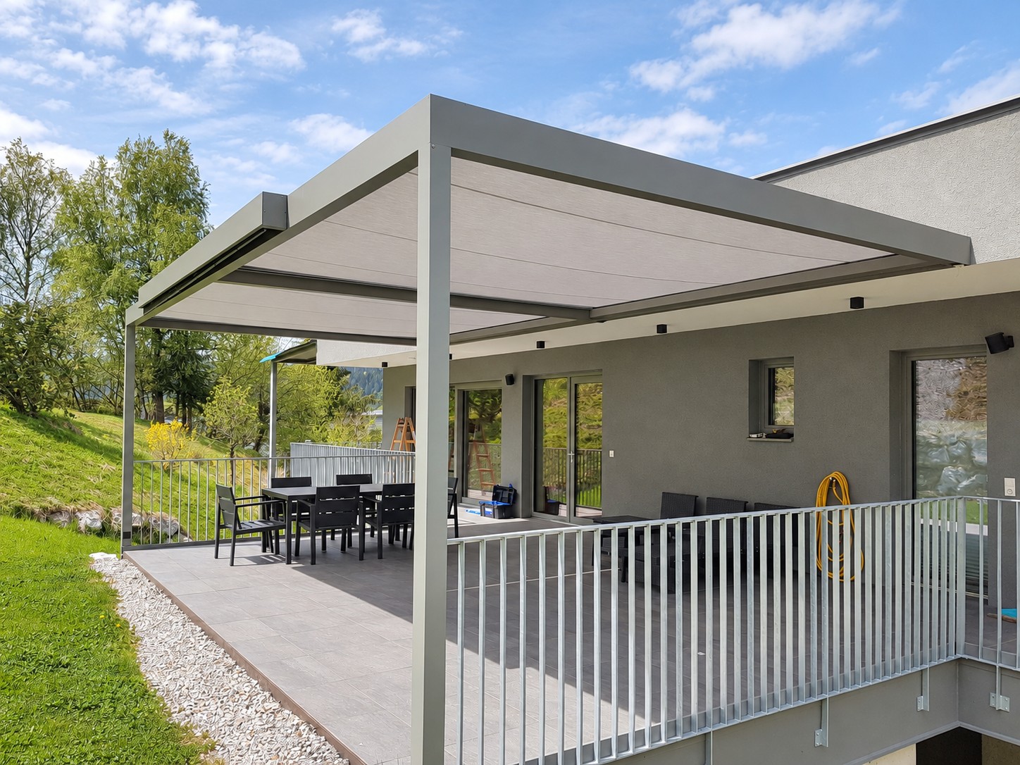 Terrasse mit großflächigem textilem Beschattungsdach am Haus